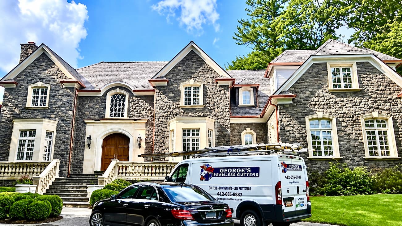 K-style copper gutters trace the roofline of a French-inspired stone home in Armonk, NY.